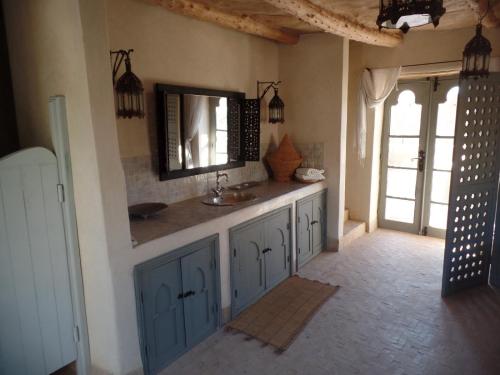 La salle de bains est pourvue d'un lavabo et d'un miroir mural. dans l'établissement Le moulin, à Taroudant