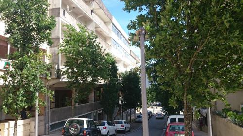 una calle con coches estacionados al lado de un edificio en Residencial S. Gião, en Valença