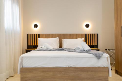 a bedroom with a large white bed with white pillows at RAFKON Luxury Apartments - Myrina in Myrina