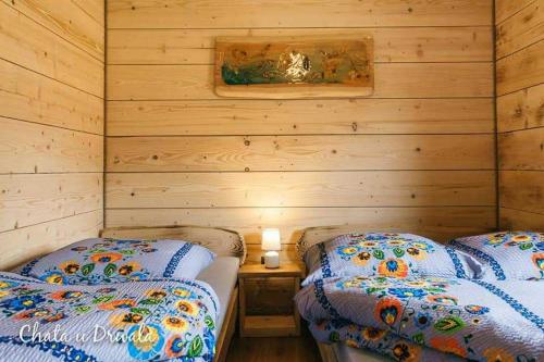 two beds in a room with wooden walls at Chata u Drwala in Bukowiec