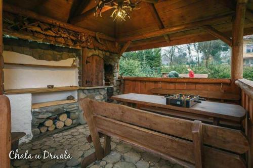 a wooden porch with a bench and a stove at Chata u Drwala in Bukowiec