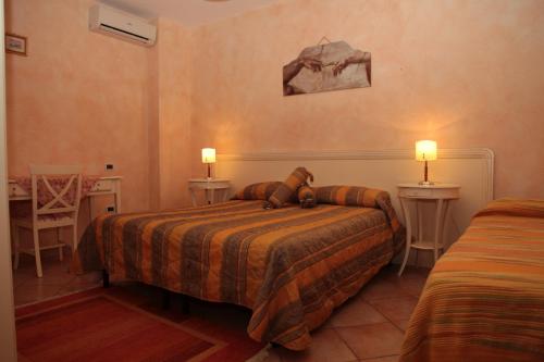 a bedroom with two beds and two tables and two lamps at Casa Vacanze Korello in Gasponi