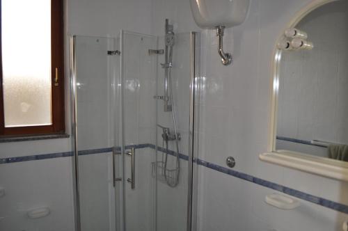 een badkamer met een glazen douche en een spiegel bij LECCE AL MARE in San Cataldo