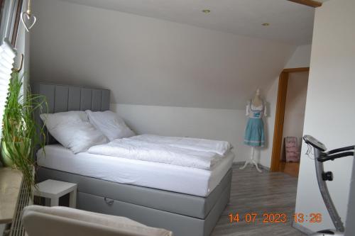 Bett in einem Zimmer mit einem Kleid an der Wand in der Unterkunft Ferienwohnung mit Ausblick in Wimmelburg in Wimmelburg