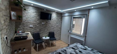 a room with a kitchen and a sink and a bed at Apartman Živković in Leskovac
