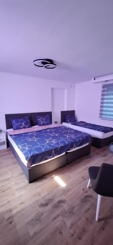 a bedroom with two beds with blue comforter at Apartman Živković in Leskovac
