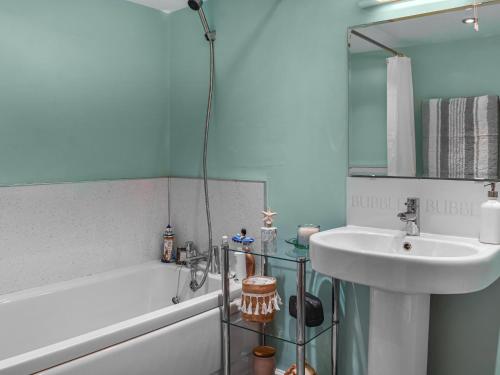 a bathroom with a sink and a bath tub and a sink at Ladybird Lodge in Glaisdale
