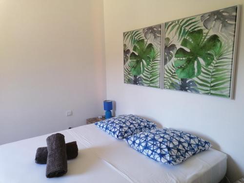 um quarto com uma cama branca e almofadas azuis em Hacienda, villaT4 de 110m2 proche de St Florent em Patrimonio
