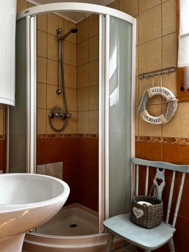 La salle de bains est pourvue d'une douche, d'un lavabo et d'une baignoire. dans l'établissement Dom Pod Długim Wiosłem, à Wiartel