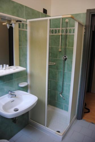 uma casa de banho com um chuveiro e um lavatório. em Hotel Capriccio em Cervia
