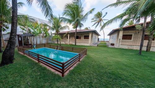 a backyard with a swimming pool and a house at Condominio Praia Caraubas in Caraúbas