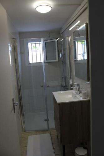 une salle de bain avec douche et lavabo dans l'établissement Appartement neuf 2 chambres avec jardin 2 places de parking securise a 300 metres de la plage, à Ronce-les-Bains