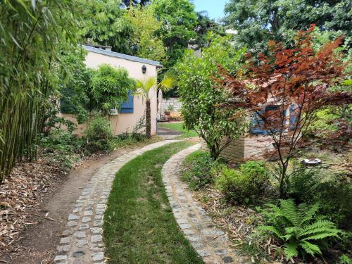 a cobblestone path in front of a house at Magnolia Cottage in Maisons-Laffitte