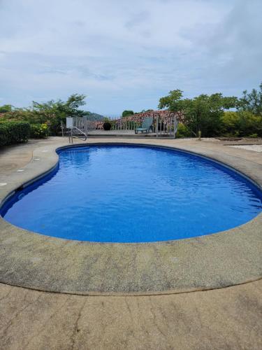 a large blue swimming pool in a driveway at Villa Roberto Vista Hermosa in Sardinal