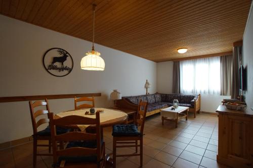 a living room with a table and a couch at Ferienapartment Candy auf der Gerlitzen in Treffen