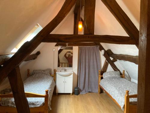 Cette chambre mansardée comprend 2 lits et un lavabo. dans l'établissement Oud-Bommerich, à Malines