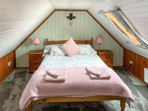 a bedroom with a bed with pink blankets and pillows at The House On The Point - Uk43807 in Kylerhea