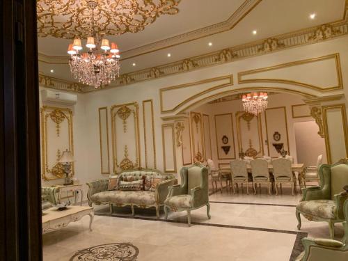 a large room with chairs and a table and a chandelier at Vila XVIP in Ras al Khaimah