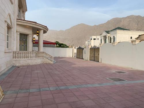 a building with a brick walkway next to a fence at Vila XVIP in Ras al Khaimah