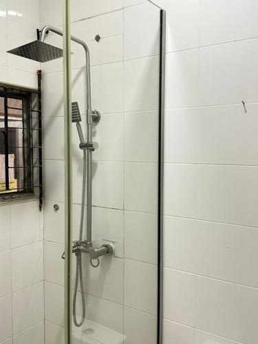 a shower in a bathroom with a glass door at Primal Msquare Apartment Ikoyi in Lagos
