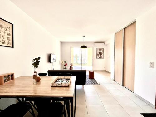 a living room with a table and a couch at Appartement Neuf avec Terrasse in Saint-Florent