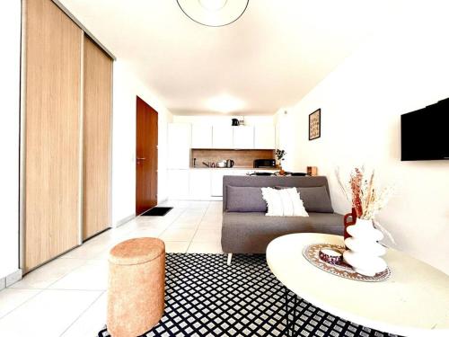 un soggiorno con divano e tavolo di Appartement Neuf avec Terrasse a Saint-Florent