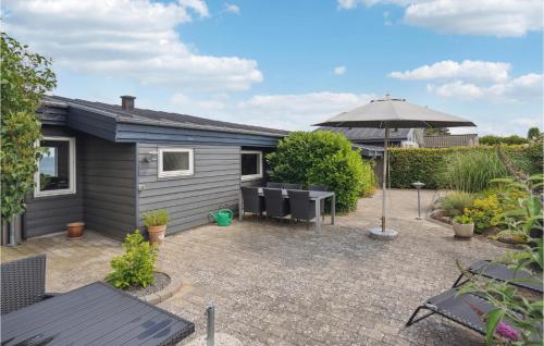 a backyard with a tiny house and an umbrella at 2 Bedroom Cozy Home In Nyborg in Nyborg