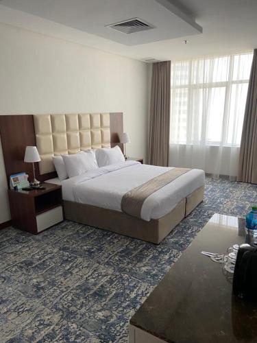 a bedroom with a large bed and a large window at Dolphin Continental Hotel in Kuwait