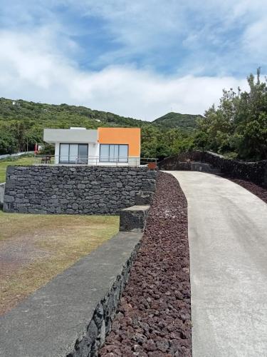 a house on a stone wall next to a road at Casa da Bella in Velas
