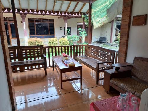 a patio with benches and a table and a table and chairs at Romadhoni Homestay in Magelang