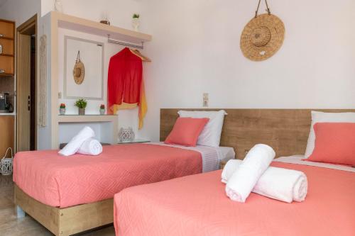 a bedroom with two beds with pink and white sheets at Stelios Apartment in Matala