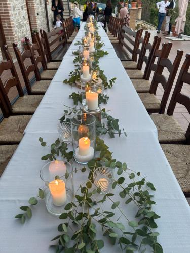 una mesa larga con velas y plantas verdes en La Tenuta dei Fiori en Ferentillo