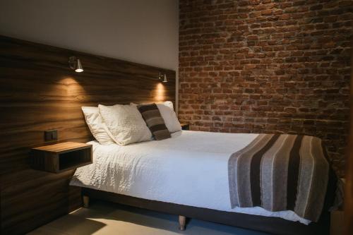 a bedroom with a bed with a brick wall at Tempo Apartamento in Villa Allende