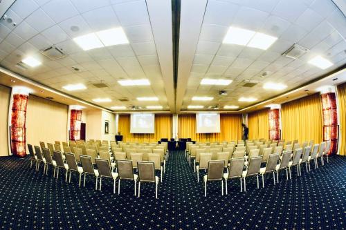 a conference room with chairs and screens in it at Hotel Tęczowy Młyn in Kielce