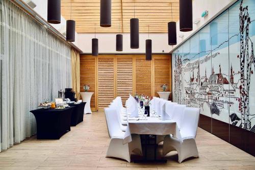 jadalnia z białymi stołami i białymi krzesłami w obiekcie Hotel Tęczowy Młyn w Kielcach