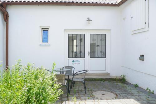 a patio with a table and chairs in front of a door at Chill & Relax Apartments Purbach in Purbach am Neusiedlersee