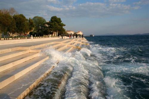 a row of steps next to the water with waters w obiekcie Apartment Olives w mieście Zadar