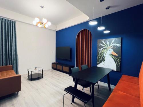 a living room with a table and a blue wall at Hebron Inn in Sanxing