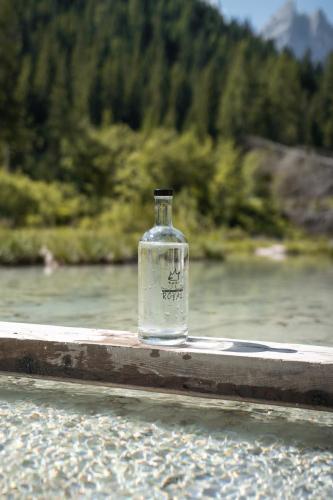 a bottle of vodka sitting on a rail next to a river at Hotel Royal in Sesto