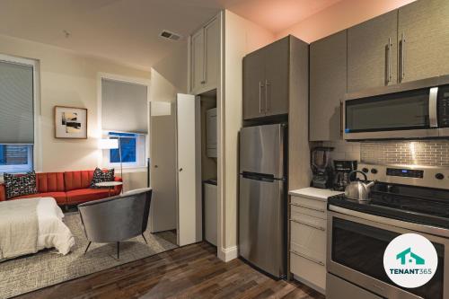 uma cozinha e sala de estar com um sofá vermelho em Inner Harbor's Best Luxury Furnished Apartments apts em Baltimore