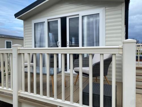 einen Balkon mit einem weißen Geländer und einem Stuhl in der Unterkunft Lancaster Views, Luxury 2022 home with Hot Tub in Tattershall