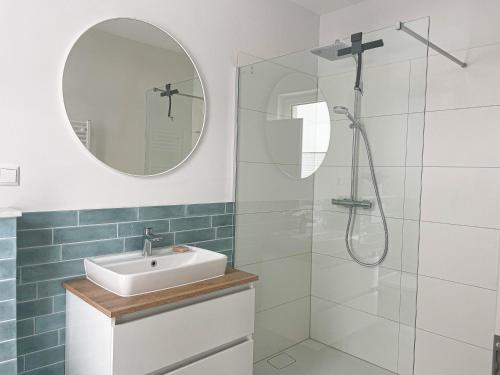 a bathroom with a sink and a shower with a mirror at Appartement - Wildecker Ferienbutze in Hönebach