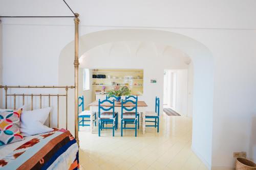 uma sala de jantar com uma mesa e cadeiras azuis em Villa QuattroVenti 1890 em Capri