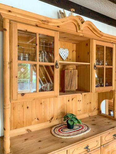 a wooden cabinet with glass doors in a kitchen at Ferienhaus Rhön-Auszeit in Bischofsheim an der Rhön
