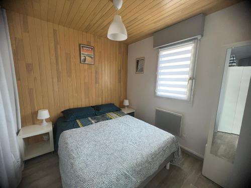 un dormitorio con una cama y una ventana en Appartement HOSSEGOR plage SUD Classé 3 étoiles, en Soorts-Hossegor