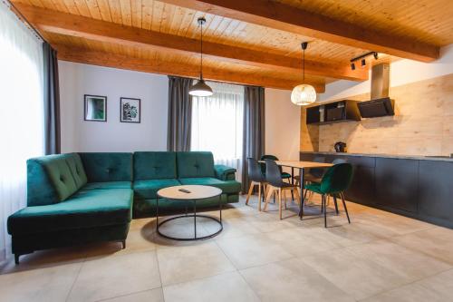 a living room with a green couch and a table at Domki Ania in Łeba