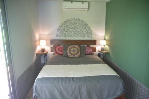 a small bedroom with a bed with two lamps at Alegria River Hideaway and Retreats in Cuajiniquil