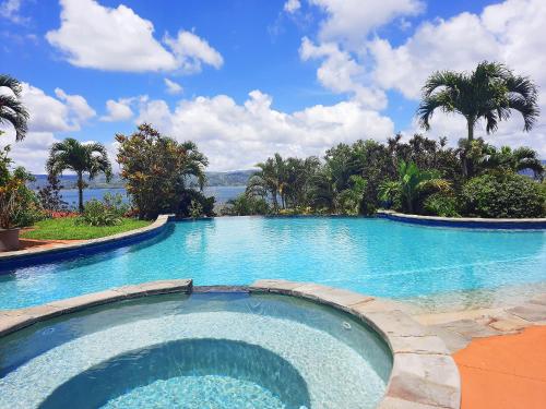 a large swimming pool with a view of the water at Beautiful Lake Arenal 2 Bed Villa - Plus Communal Pool, Gym, Massage in Tronadora