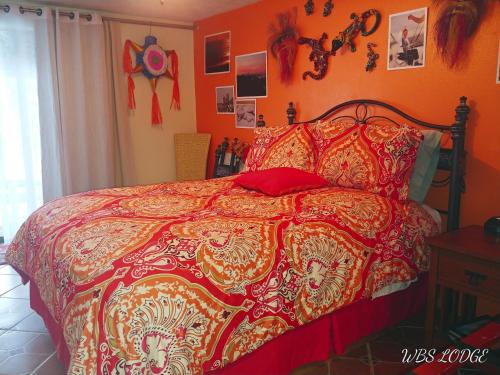 a bedroom with a bed with a red comforter at Whitebird Summit BNB in Whipsaw Saddle
