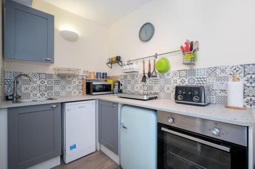 a kitchen with gray and white tiles on the wall at The Ramblers' Rest - Princetown in Princetown